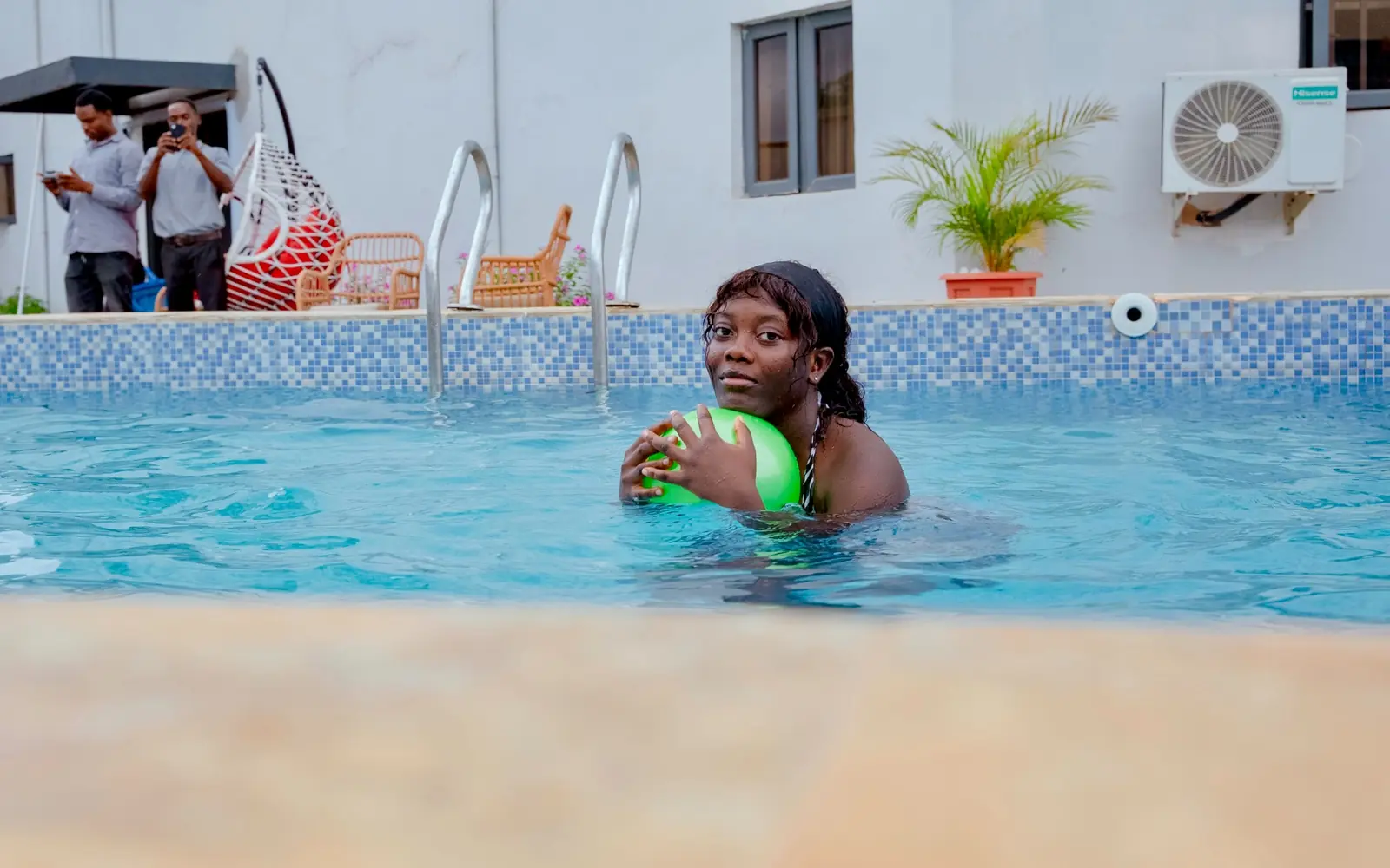 Guest relaxing beside the swimming pool at Diplomat Enclave Suites in Abuja