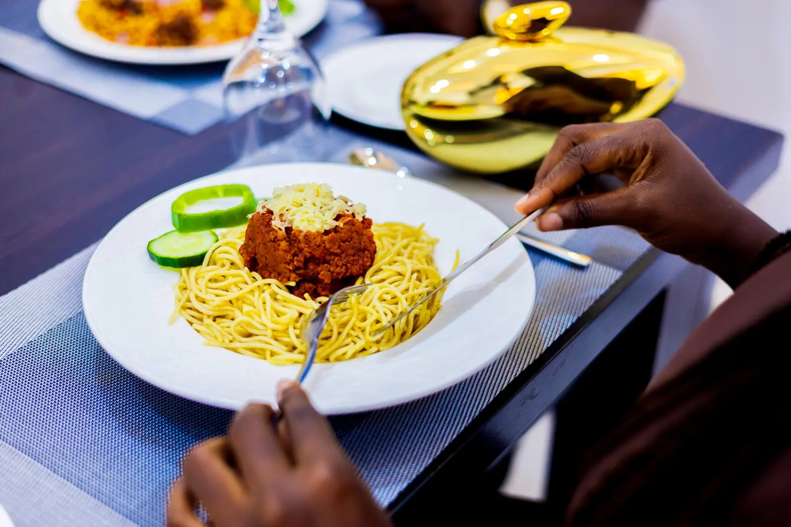 Guest enjoying a freshly served spaghetti meal at Diplomat Enclave Suites restaurant in Abuja